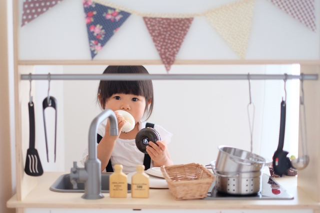 ままごとキッチンで遊ぶ子ども