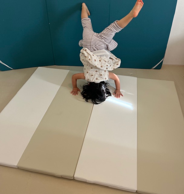 プレイマットの上で体操する子ども